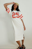 Woman wearing a white dress with red numbers on a plain background